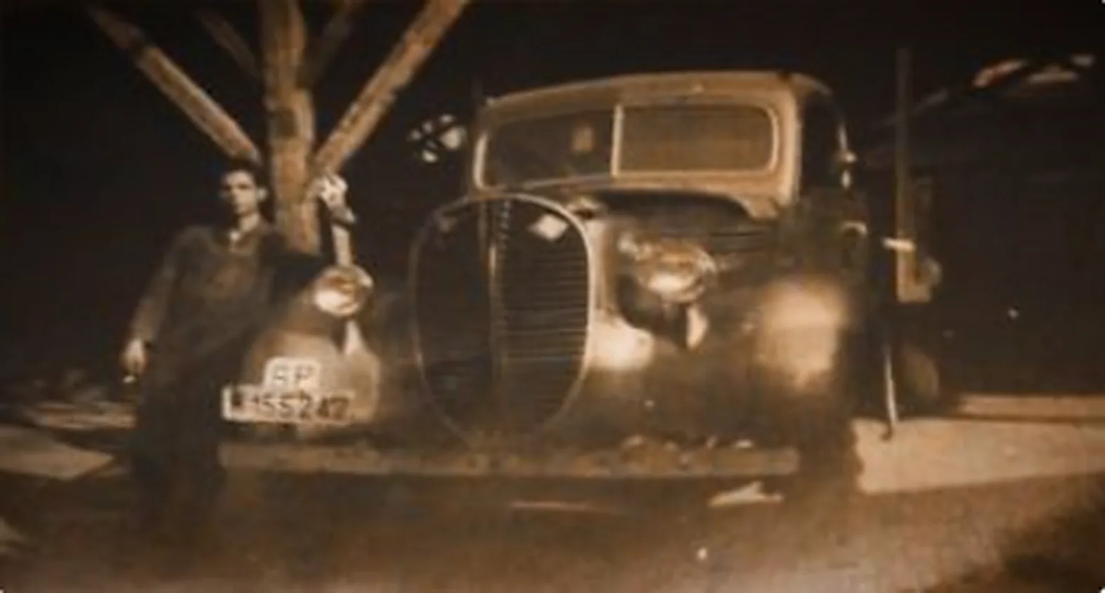 Fotografía de los años 50: un hombre apoyado en el primer camión de la familia, en Madrid.
